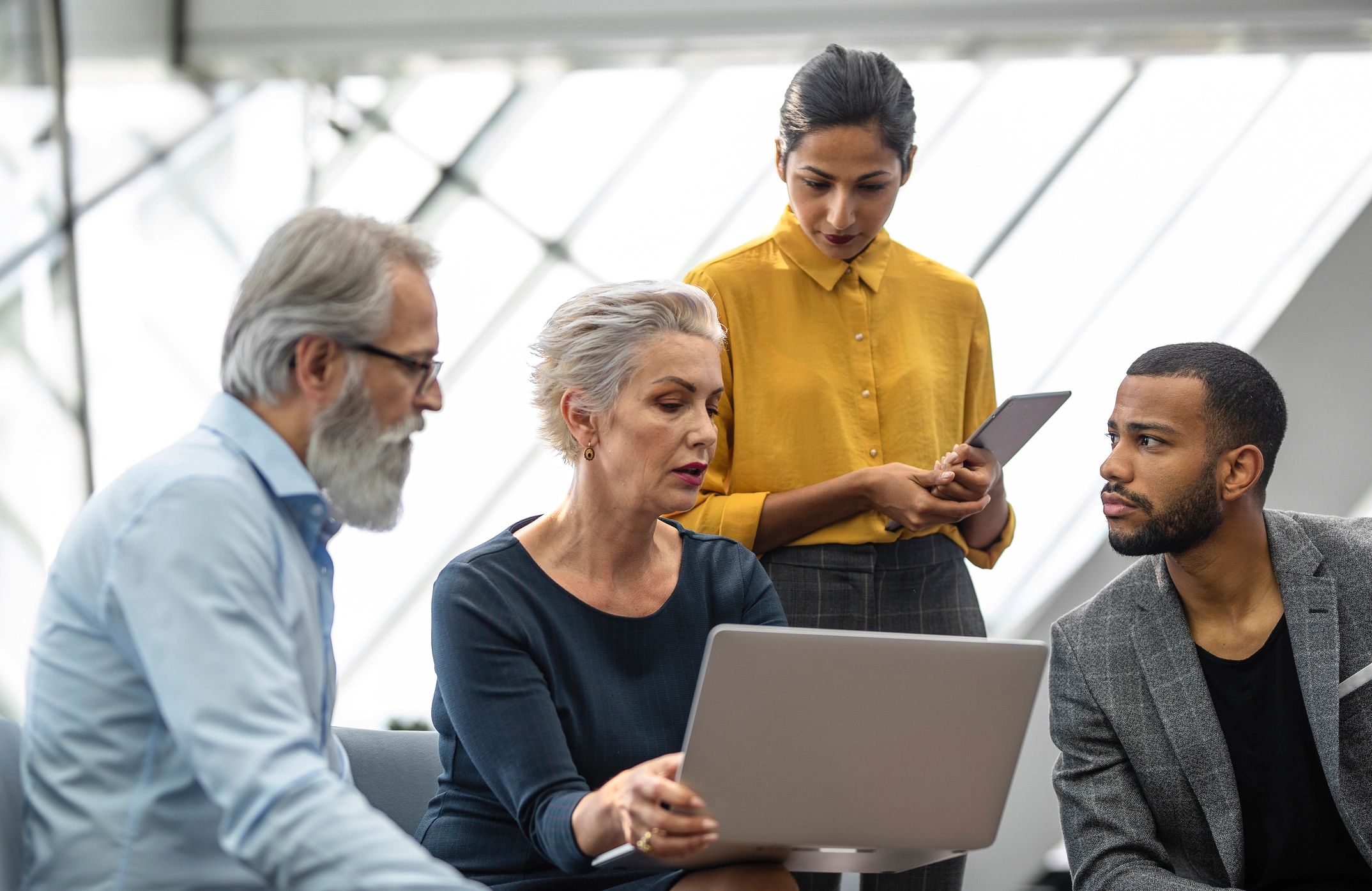 Team collaborating around a tablet in a modern office